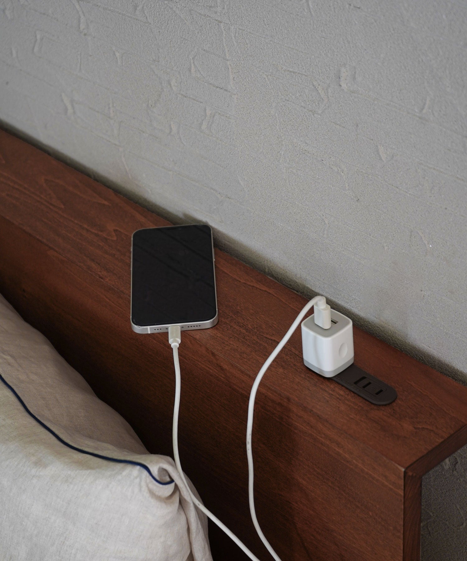 ヘッドボード上にはコンセント付き。10cmの奥行きもあるので、スマホや時計を置くのにも便利です。