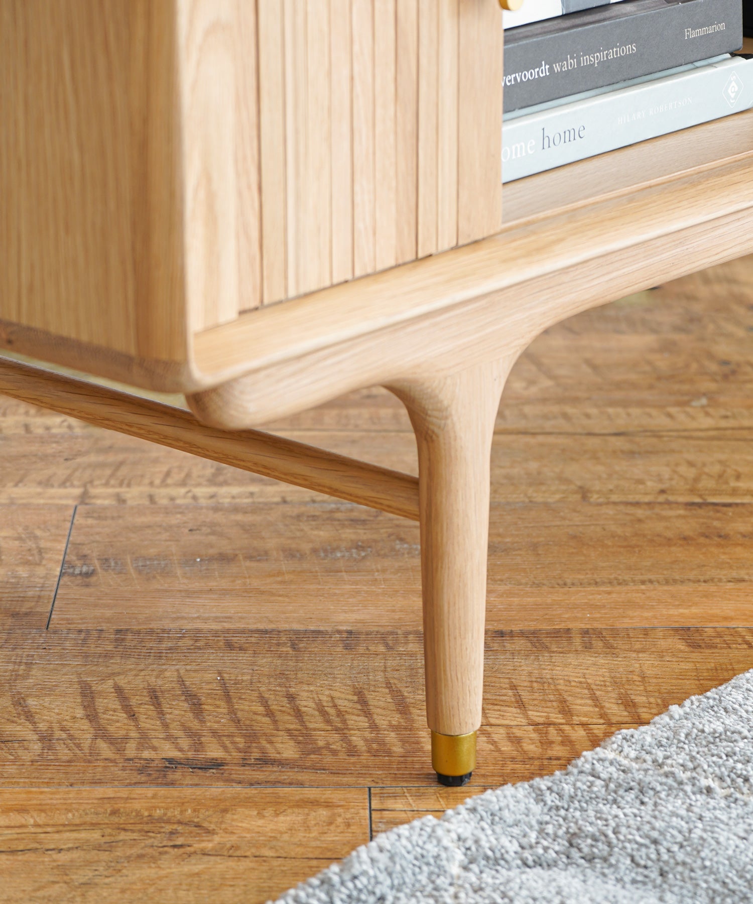 細部まで丸みにこだわったデザイン。脚先は真鍮色の金具とアジャスターが付いています。